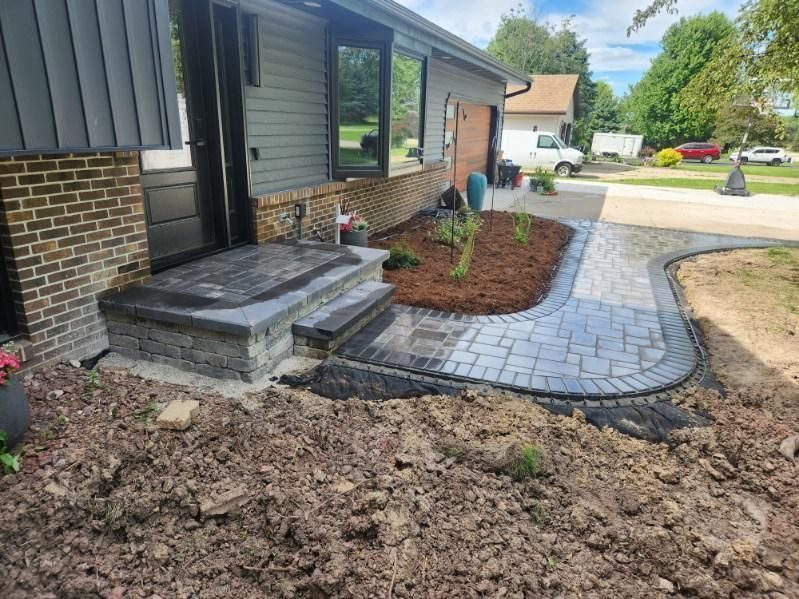 After: new paver walkway, brick steps, and fresh mulch beds at the same home