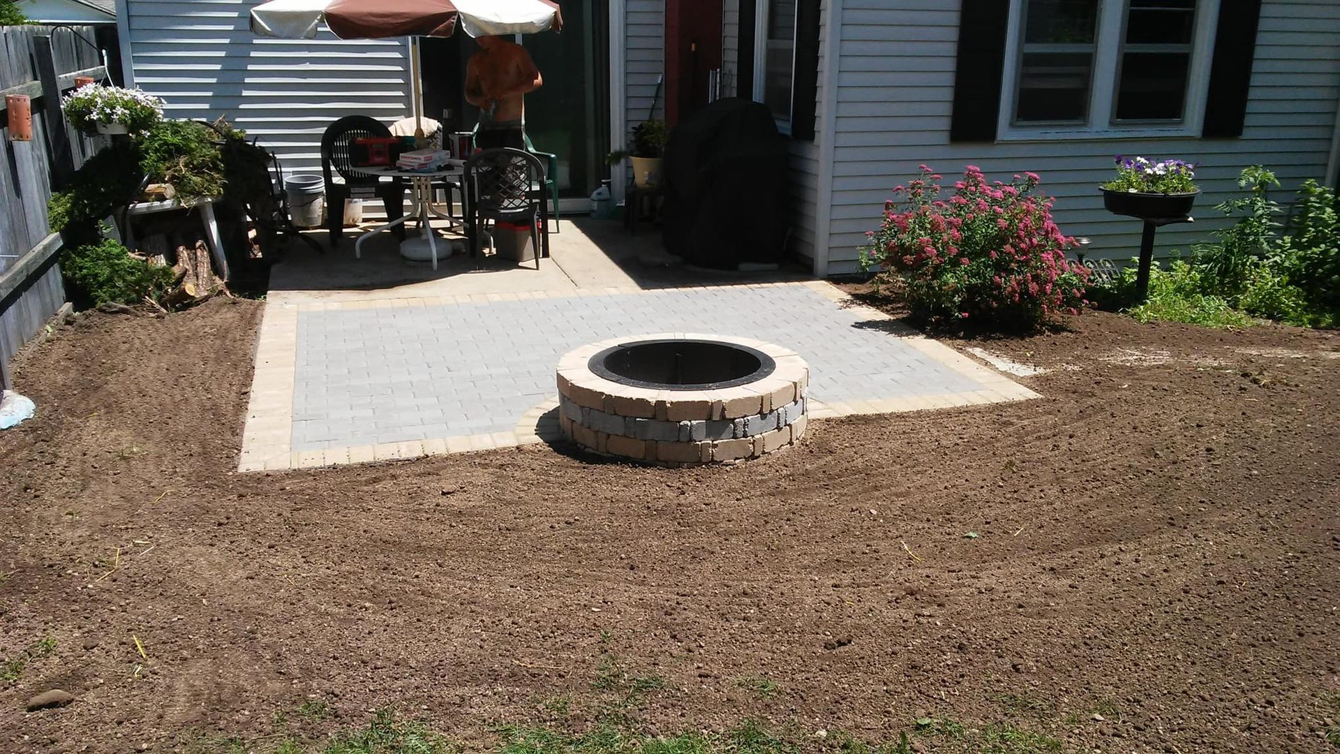 Finished paver patio with a stone fire pit in a Wisconsin backyard