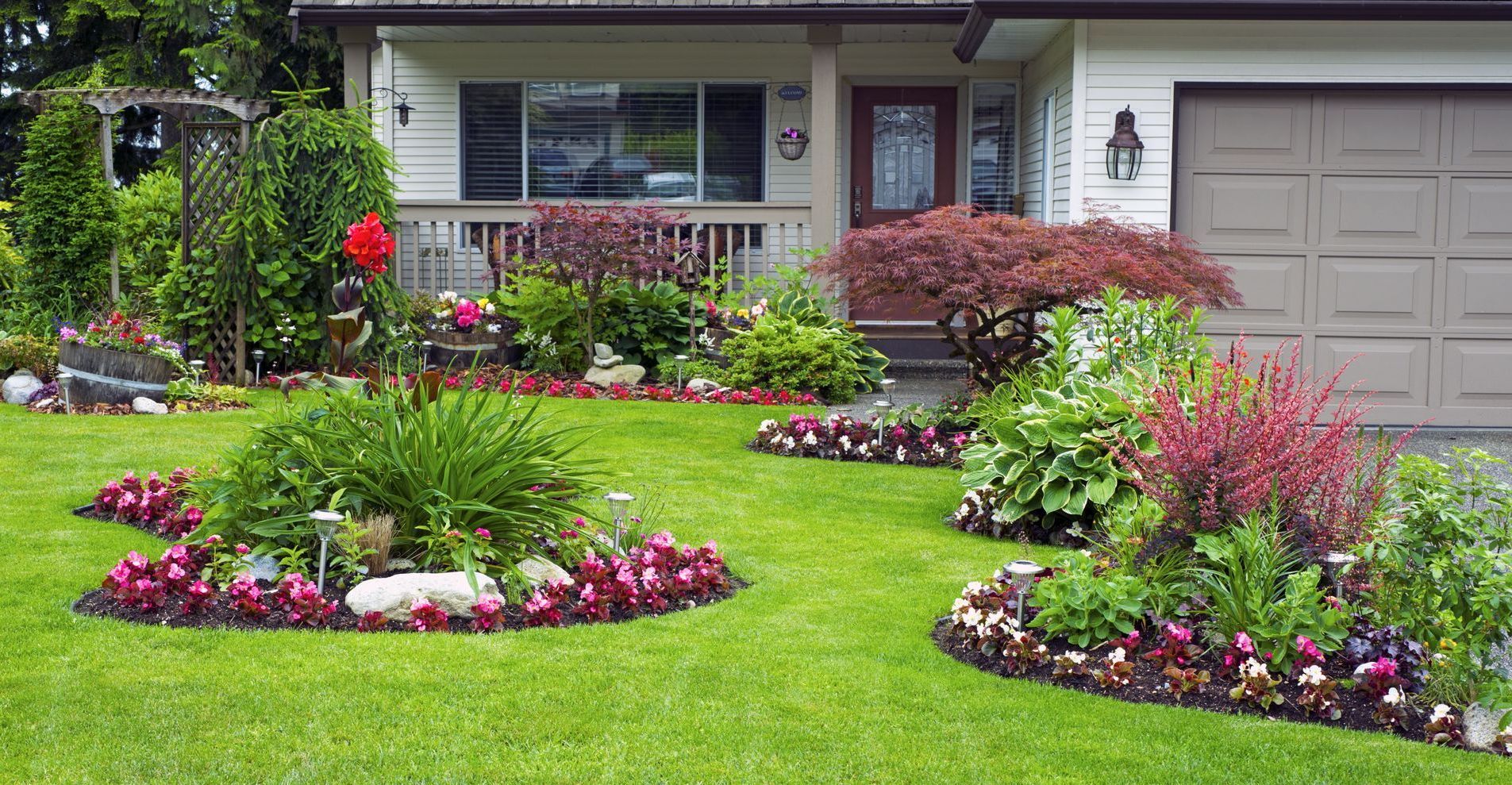 Backyard with a round stone fire pit, paver patio, and curved raised planter beds